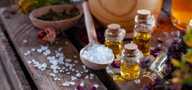 Essential oil bottles with dry ingredients and white crystals in wood spoon